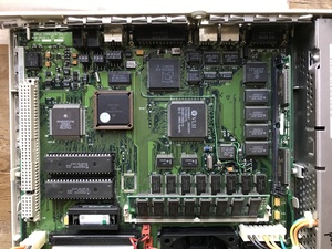 Closeup of the logic board on the LC III, which has had its old electrolytic capacitors replaced with tantalum capcitors. Alongside the 68030 CPU, the socket for a 68882 FPU is also populated, along with additional SIMM for system RAM and one for VRAM as well