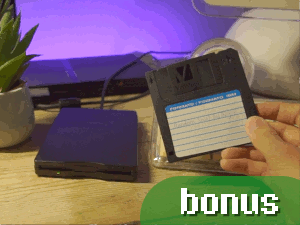 Link to the bonus segment of this video. The thumbnail shows a generic USB floppy drive set up with an iMac G4, with a Verbatim floppy disk being held up that has a sticker label that says "Random Stuff And Things!" The LED strip light on my desk was turned on here and set to purple, and you can see a PS2 slim along with a small desk plant in the background. A green rounded button is added to the thumbnail, which says "bonus" in a pixel style font