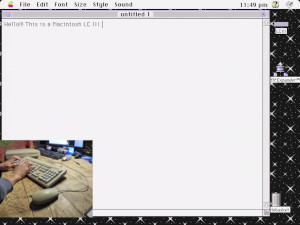 Video of a Direct VGA capture screen recording of a Macintosh LC III, featuring a small camera view in the corner pointed at the keyboard and mouse as I'm using it. In the video, I open up SimpleText in System 7.5 and type out the following: "Hello!!! This is a Macintosh LC III. Typing this with the AppleDesign Keyboard. [smiley emoticon face] Happy MARCHintosh! "