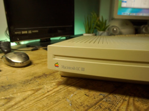 Video demonstrating a Macintosh LC III. This is the intro to that video, which starts with a screen recording of MilkyTracker on Mac OS 10.4 playing a module file. This then transitions into some b-roll clips showing around the LC itself with the front and back of the case in particular. I then show some b-roll of inside the machine, with the recapped logic board, 80MB Quantum ProDrive ELS hard drive, 68882 FPU and other components. I then show me putting the case of the LC back on, where some slightly blurred out text is displayed reading "be careful with the 90s plastics..." The rest of the intro shows me getting the LC III set up, with a DB15 to VGA adapter going to an Atlona scaler, connecting the keyboard and mouse and plugging the system into power. The clip ends by zooming out to reveal the computer set up, before powering on.