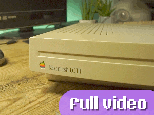 Link to the full finished video. The thumbnail is a closeup of the front case of the LC III, showing the rainbow Apple logo and Garamound font branding on the left side. The computer is placed on a desk which has an LED strip light behind it set to green. Other items visible include a 15 inch 720p TV on the left and an iMac G4 to the right. A purple rounded button is added to the thumbnail, which says "full video" in a pixel style font