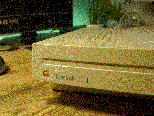 Closeup of the front case on a Macintosh LC III, showing the rainbow Apple logo and Garamound font branding for the computer